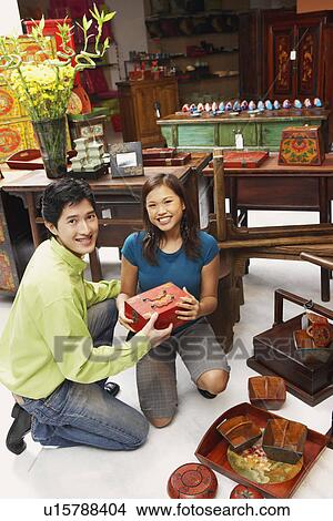 Portrait of a young couple choosing merchandise in a store View Large Photo Image Picture - Portrait of a young couple choosing merchandise in a store. Fotosearch