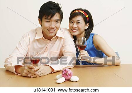 Portrait of a young couple holding glasses of wine and smiling View Large Photo Image Stock Image - Portrait of a young couple holding glasses of wine and smiling. Fotosearch