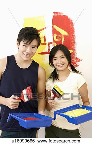 Portrait of a young couple holding paintbrushes with paint trays and smiling View Large Photo Image Stock Photograph - Portrait of a young couple holding paintbrushes with paint trays and smiling. Fotosearch