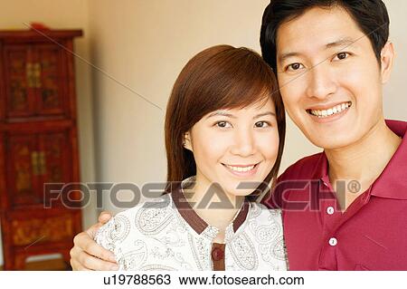 Stock Image - Portrait of a young couple smiling. Fotosearch
