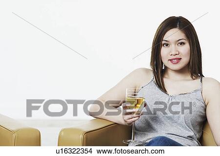 Portrait of a young woman holding a wineglass View Large Photo Image Picture - Portrait of a young woman holding a wineglass. Fotosearch
