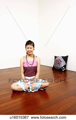 Portrait of a young woman sitting on the floor and smiling View Large Photo Image Stock Photo - Portrait of a young woman sitting on the floor and smiling. Fotosearch