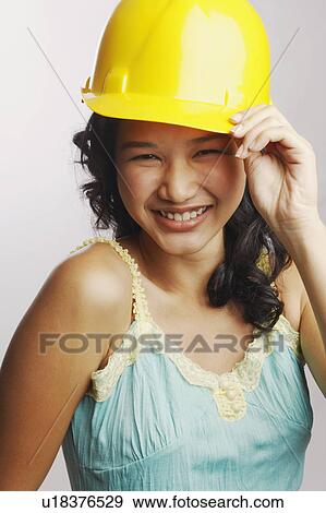 Stock Photo - Portrait of a young woman wearing a cap and smiling. Fotosearch
