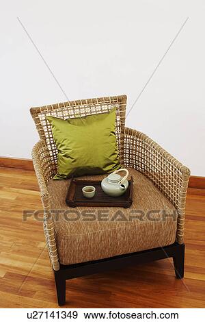 Stock Photo - Teapot and a tea cup with a tray in an armchair. Fotosearch