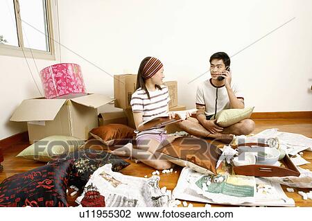 Young woman sitting holding a directory with a young man talking on the telephone View Large Photo Image Stock Image - Young woman sitting holding a directory with a young man talking on the telephone. Fotosearch