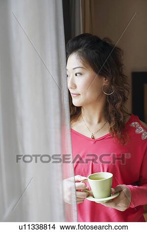 Close-up of a young woman holding a tea cup View Large Photo Image Picture - Close-up of a young woman holding a tea cup. Fotosearch