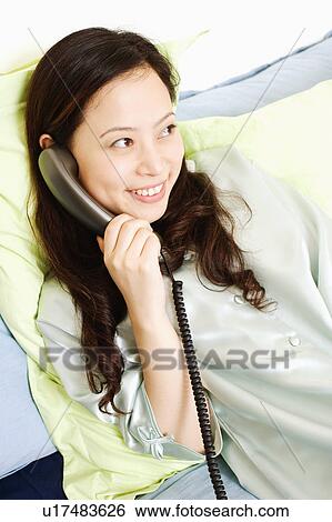 Close-up of a young woman talking on the telephone View Large Photo Image Stock Photograph - Close-up of a young woman talking on the telephone. Fotosearch
