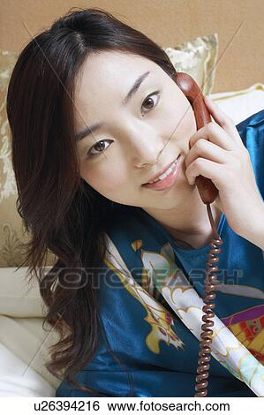 Stock Photograph - Close-up of a young woman talking on the telephone. Fotosearch