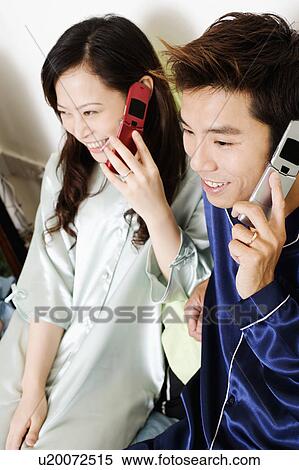 High angle view of a mid adult man with a young woman using mobile phones View Large Photo Image Stock Photography - High angle view of a mid adult man with a young woman using mobile phones. Fotosearch