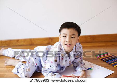 Stock Image - Portrait of a boy drawing on paper. Fotosearch