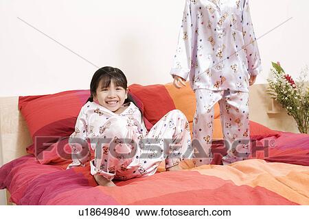 Portrait of a girl leaning on bed and boy standing beside her View Large Photo Image Stock Image - Portrait of a girl leaning on bed and boy standing beside her. Fotosearch