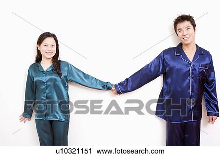 Stock Image - Portrait of a mid adult man and a young woman holding hands and smiling. Fotosearch
