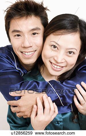 Portrait of a mid adult man hugging a young woman from behind View Large Photo Image Stock Photo - Portrait of a mid adult man hugging a young woman from behind. Fotosearch