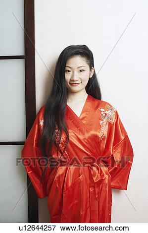 Portrait of a young woman leaning against a wall View Large Photo Image Stock Photo - Portrait of a young woman leaning against a wall. Fotosearch