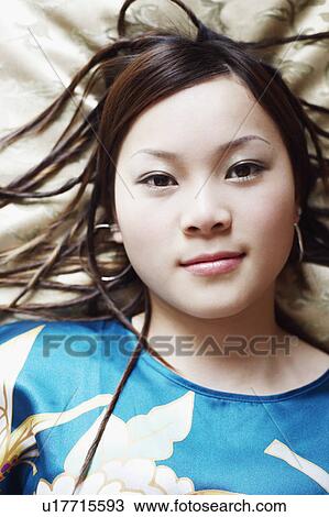 Stock Image - Portrait of a young woman lying on her back. Fotosearch