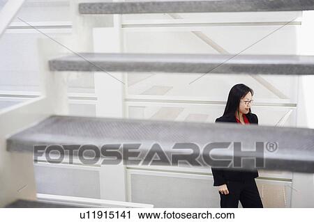 Stock Image - High angle view of a businesswoman reading a newspaper. Fotosearch