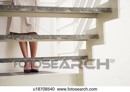 Low section view of a young woman standing on a staircase View Large Photo Image Stock Image - Low section view of a young woman standing on a staircase. Fotosearch