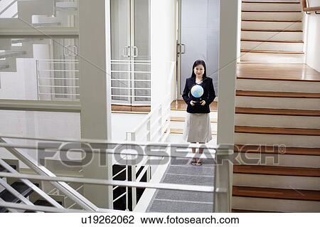 Portrait of a businesswoman holding a globe and smiling View Large Photo Image Stock Image - Portrait of a businesswoman holding a globe and smiling. Fotosearch