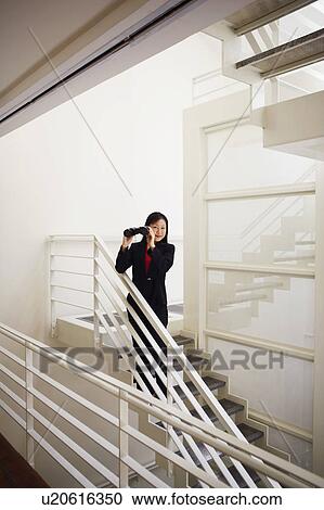 Portrait of a businesswoman holding a pair of binoculars and smiling View Large Photo Image Stock Image - Portrait of a businesswoman holding a pair of binoculars and smiling. Fotosearch