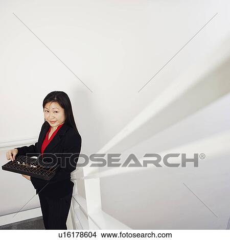 Portrait of a businesswoman holding an abacus and smiling View Large Photo Image Picture - Portrait of a businesswoman holding an abacus and smiling. Fotosearch
