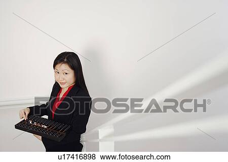 Portrait of a businesswoman holding an abacus and smiling View Large Photo Image Stock Photo - Portrait of a businesswoman holding an abacus and smiling. Fotosearch