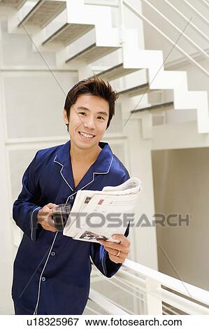 Portrait of a mid adult man holding a cup of coffee and reading a newspaper View Large Photo Image Stock Photo - Portrait of a mid adult man holding a cup of coffee and reading a newspaper. Fotosearch
