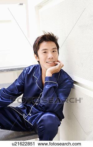 Stock Image - Portrait of a mid adult man smiling with his hand on his chin. Fotosearch