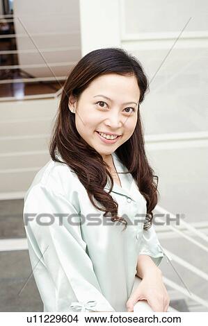 Portrait of a young woman standing by a railing View Large Photo Image Picture - Portrait of a young woman standing by a railing. Fotosearch