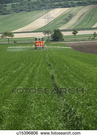 Stock Photograph - Spraying the farm fields. Fotosearch