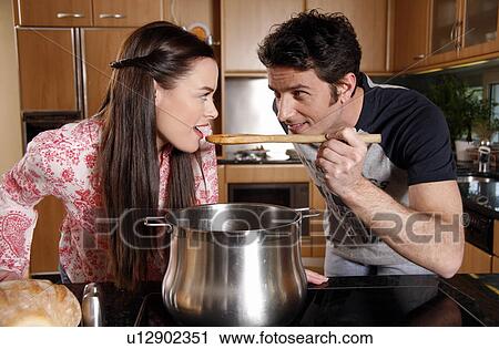 Stock Image - A couple cooking together. Fotosearch