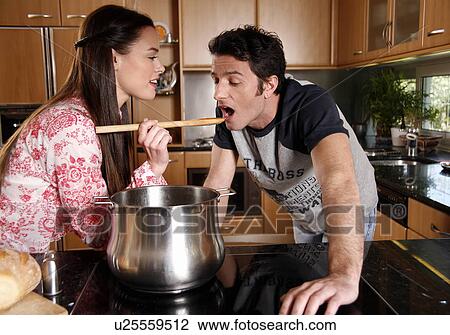 Stock Image - A couple cooking together. Fotosearch