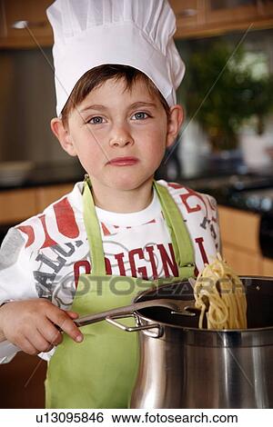 Stock Photograph - Boy cooking spaghetti. Fotosearch