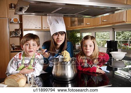 Picture - Children cooking spaghetti. Fotosearch