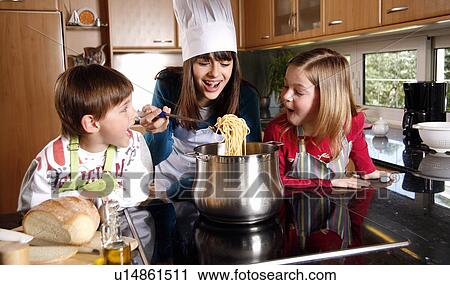 Stock Image - Children cooking spaghetti. Fotosearch