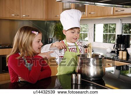 Stock Photo - Children cooking spaghetti. Fotosearch