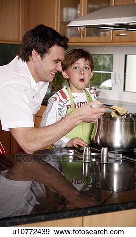 Stock Photo - Father and son cooking spaghetti. Fotosearch