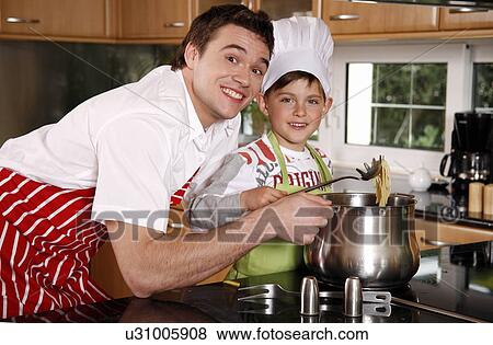 Stock Photo - Father and son cooking spaghetti. Fotosearch