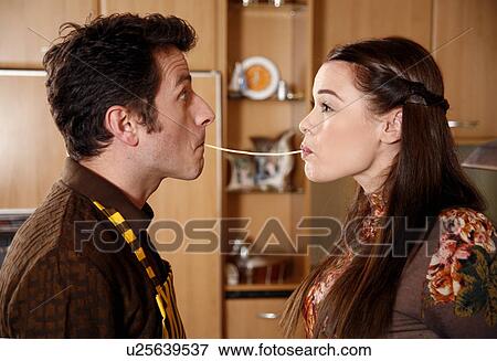 Stock Photo - Man and woman sharing a strand of spaghetti. Fotosearch