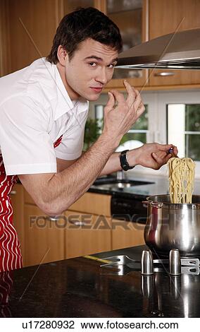 Stock Image - Man cooking spaghetti. Fotosearch