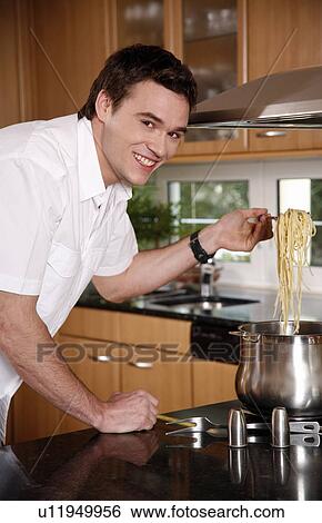 Stock Photograph - Man cooking spaghetti. Fotosearch