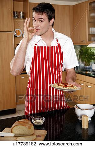 Stock Image - Man enjoying his cooking. Fotosearch