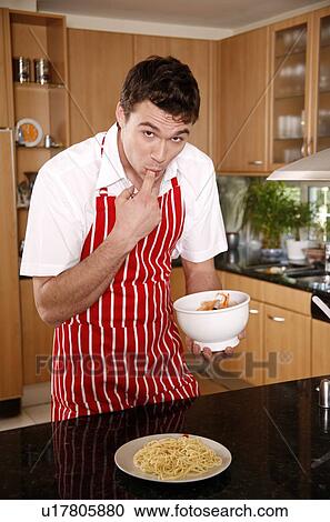 Stock Image - Man tasting spaghetti sauce. Fotosearch