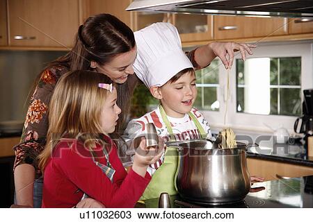 Stock Image - Mother and children cooking . Fotosearch