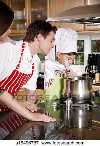 Stock Photo - Parents and son cooking spaghetti. Fotosearch