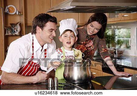 Stock Photo - Parents and son cooking spaghetti. Fotosearch