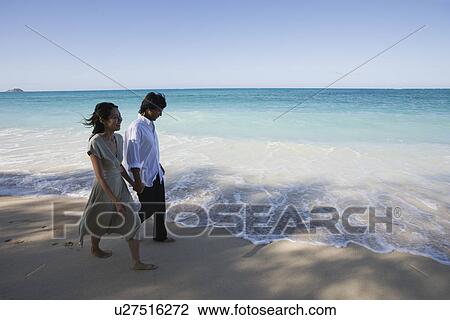 A young couple walking on beach View Large Photo Image Stock Image - A young couple walking on beach. Fotosearch