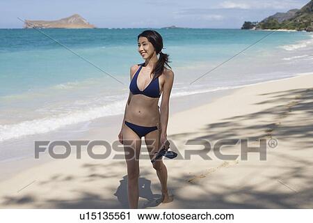 A young woman walking on beach View Large Photo Image Stock Image - A young woman walking on beach. Fotosearch