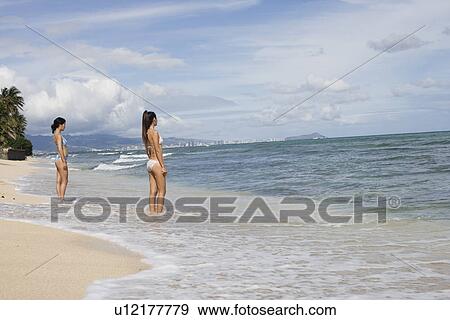 Profile of young women standing at beach View Large Photo Image Stock Photo - Profile of young women standing at beach. Fotosearch