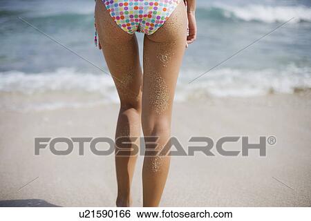 Rear view of a young woman standing on beach View Large Photo Image Stock Photograph - Rear view of a young woman standing on beach. Fotosearch