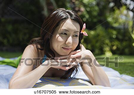 A smiling young woman relaxing in garden View Large Photo Image Stock Photography - A smiling young woman relaxing in garden. Fotosearch